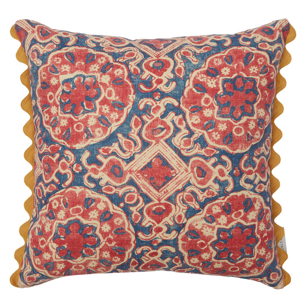 Red and blue floral geometric print cushion with yellow scalloped trim