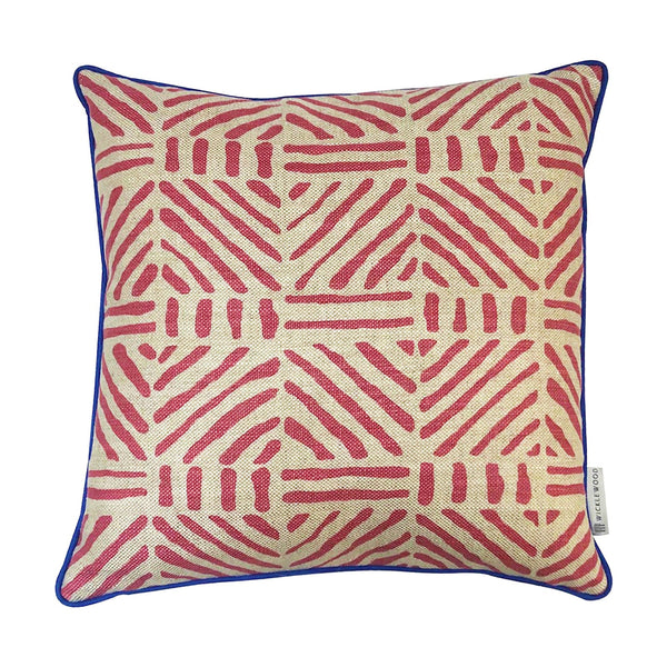 Geometric striped red woven cushion with navy blue trim.