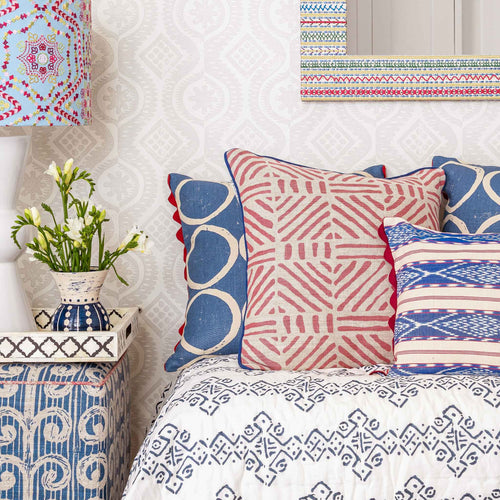 Circle print blue square cushion with red scalloped trim.